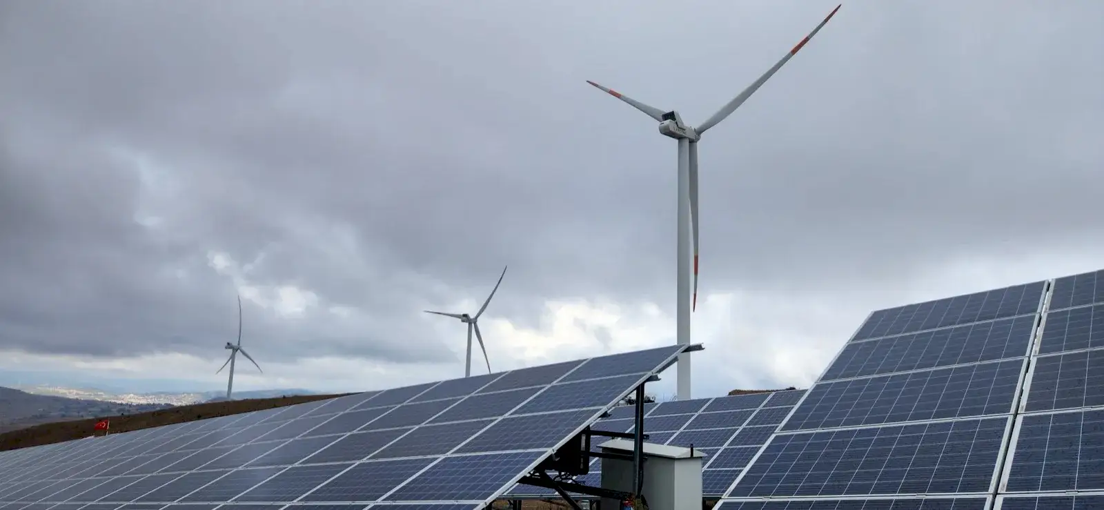 Arazi güneş enerjisi santrali — panel sahası ve rüzgar türbinleri